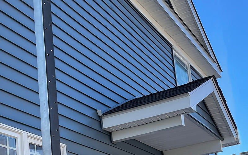 Photo of side of a New Jersey home having blue vinyl siding installed by Everest Construction Group